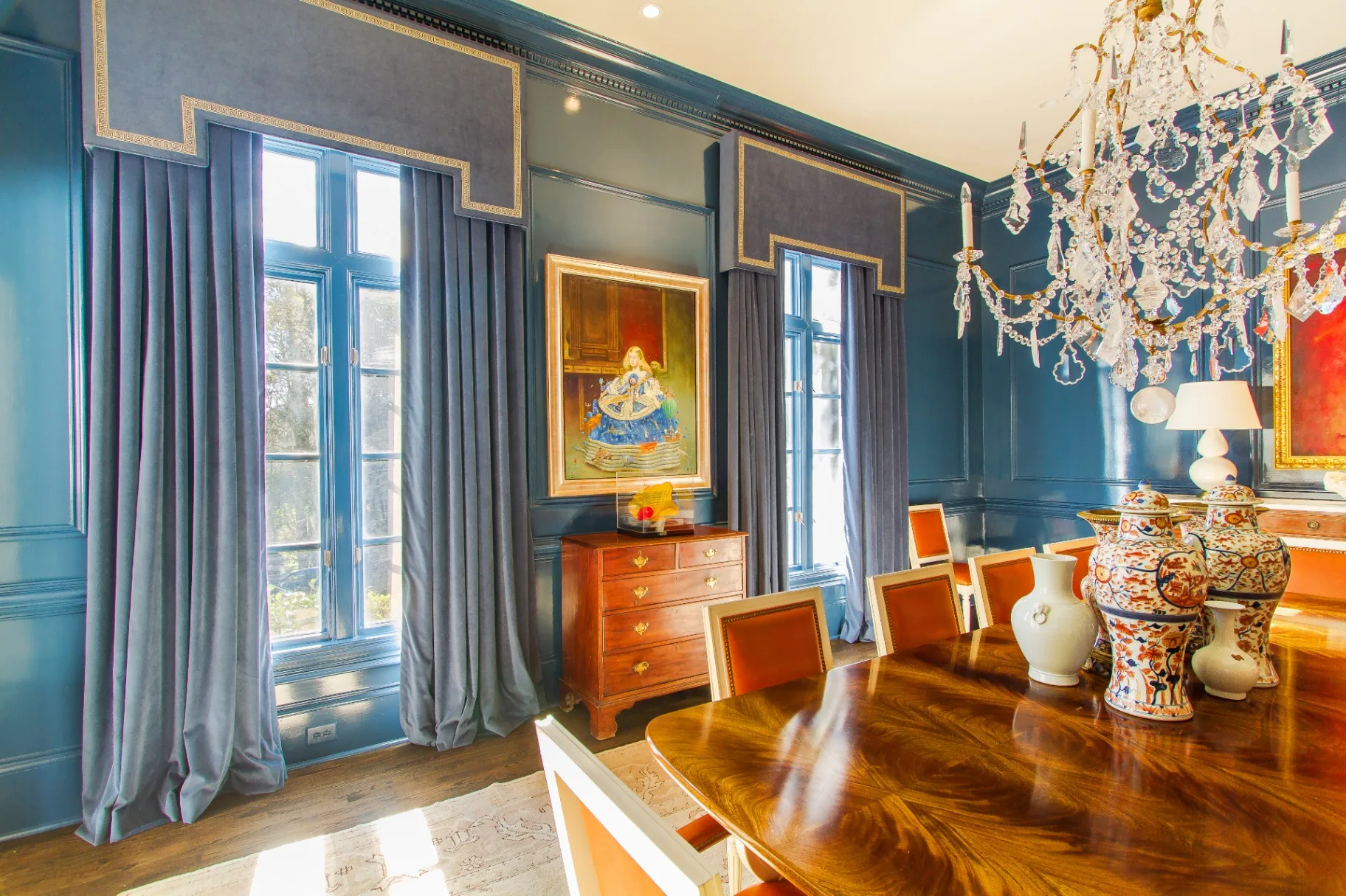 Formal dining room with custom blue velvet drapery and gold trim cornices
